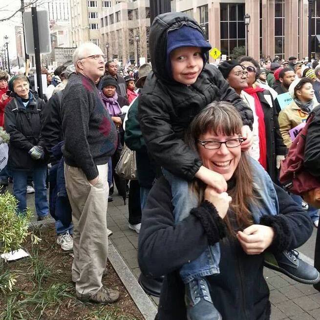 Photo of Ruby with her son on her shoulders at a previous march